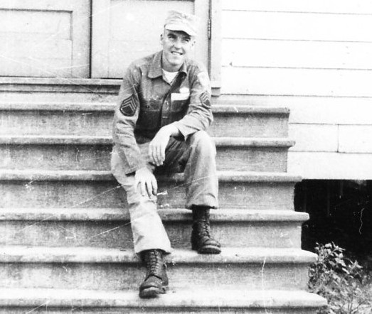 A man sitting on the steps of a house.